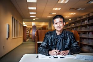 Student in the library, studying for exam.
