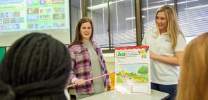 Two students presenting elementary education exercise in front of class.