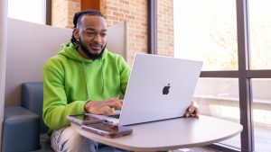 Student working on a laptop in a campus study space.