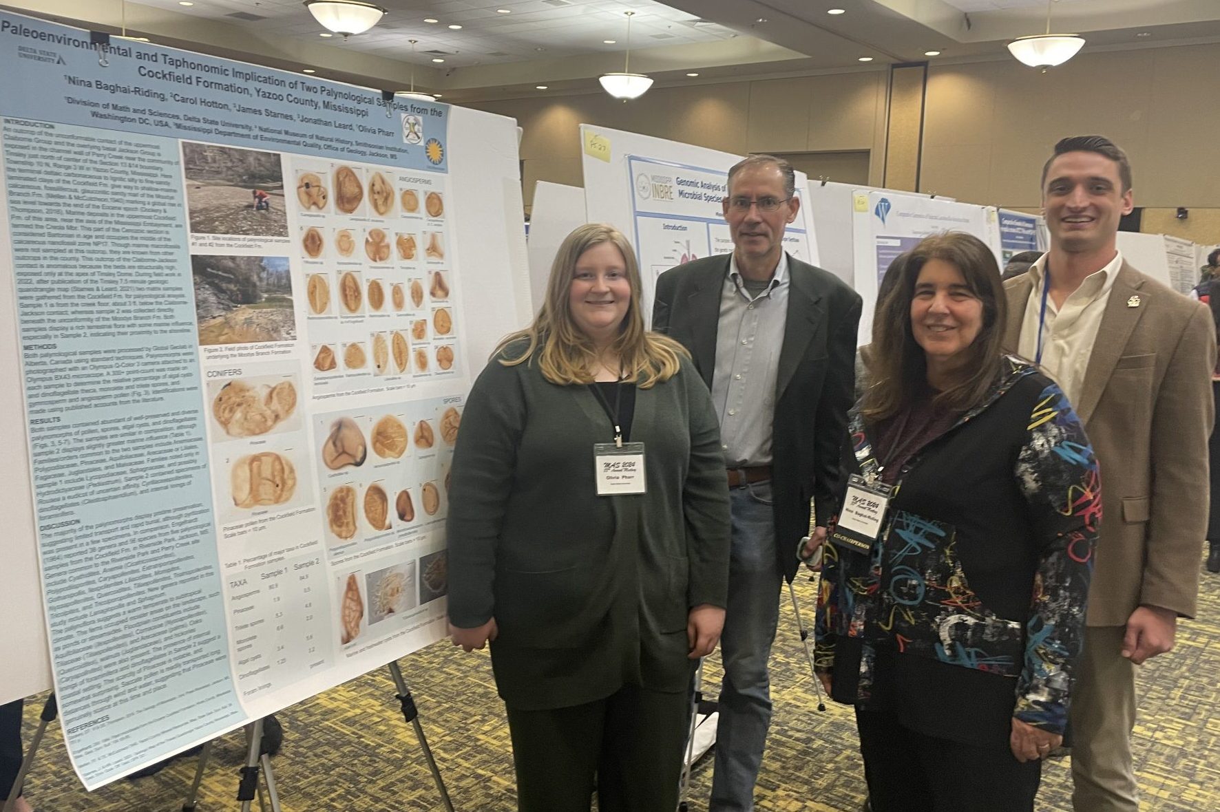 Delta State students and faculty standing in front of research poster at a conference.