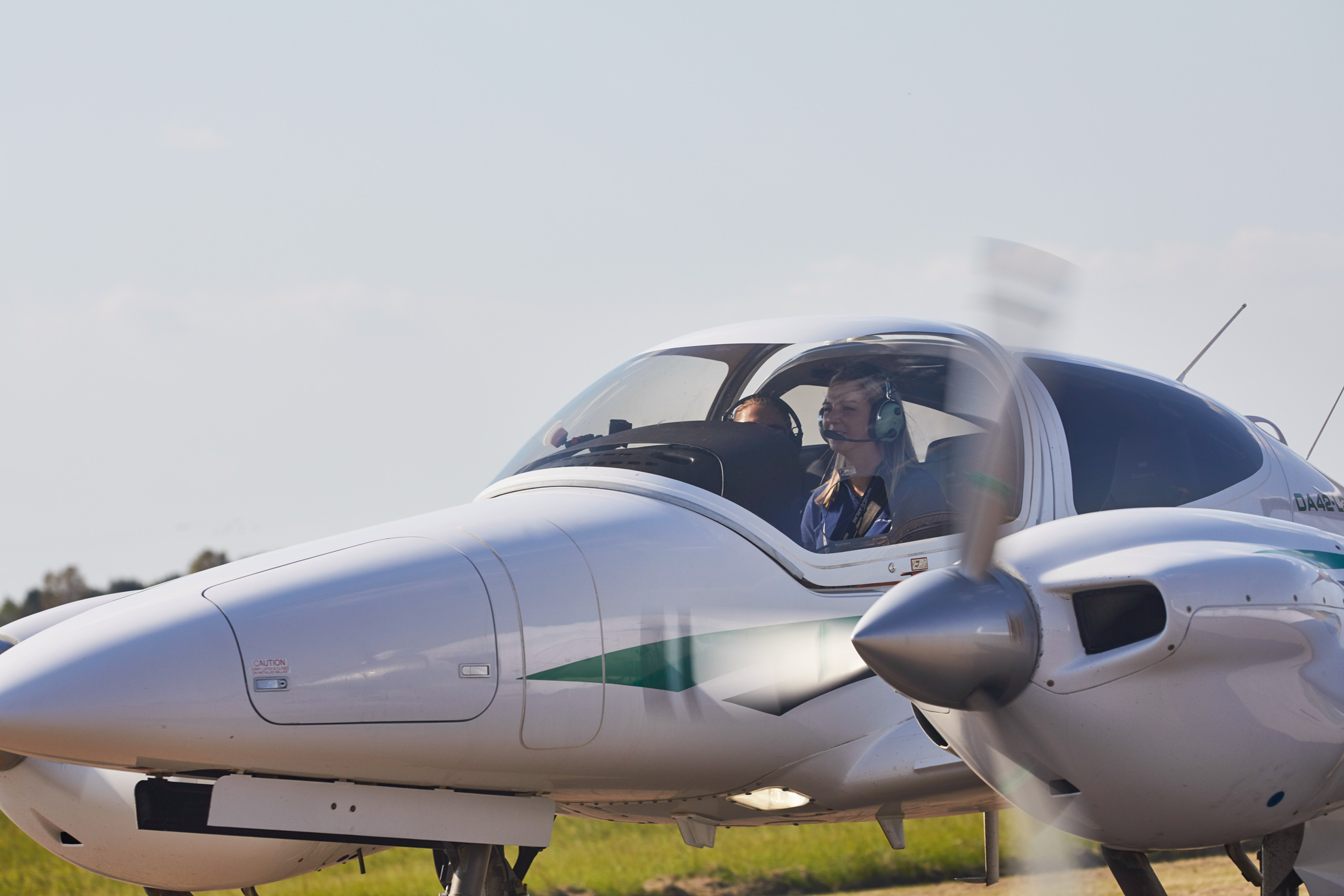 Student pilots seated inside a twin-engine training aircraft preparing for flight.