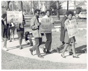 Students marching with signs on Delta State campus.