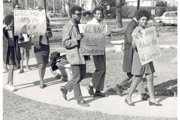 Students marching with signs on Delta State campus.