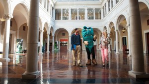 Students and Delta State Mascot, smiling while walking through administrative building.