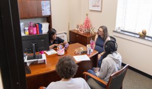 Delta State financial aid counselor meeting with students in an office setting, discussing FAFSA and financial aid options.
