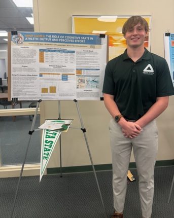 Jacob Runyon stands next to his research poster.
