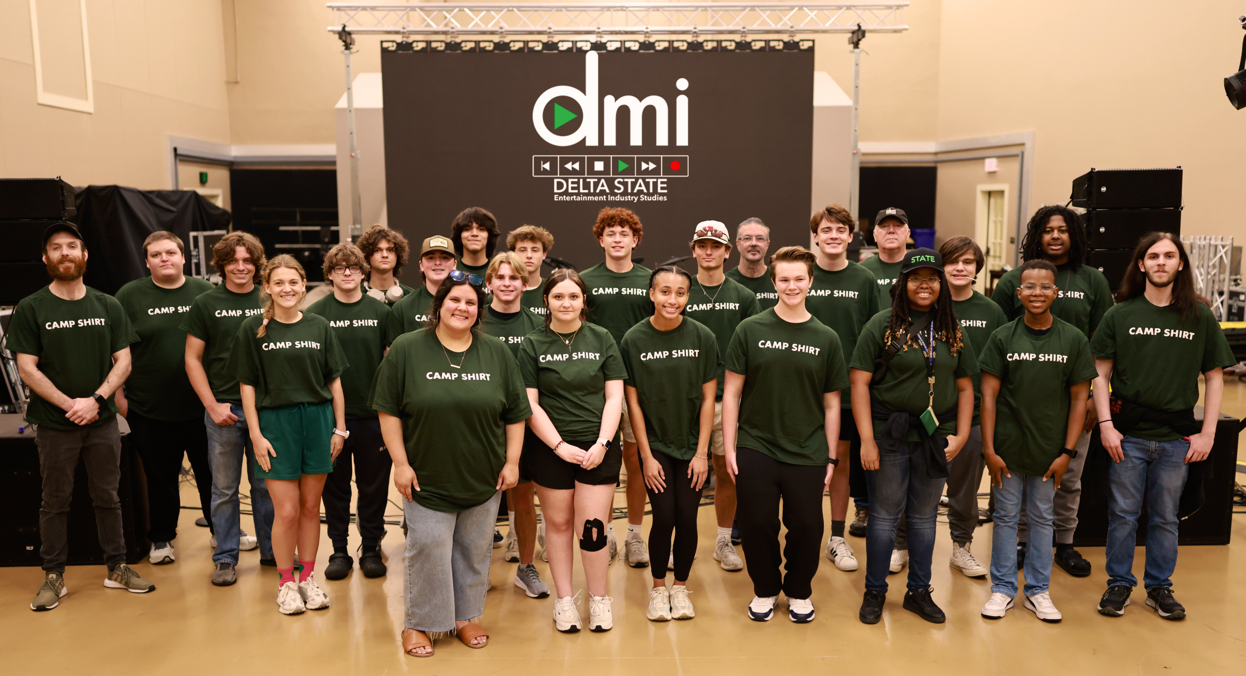 a group of students in green shirts standing in rows