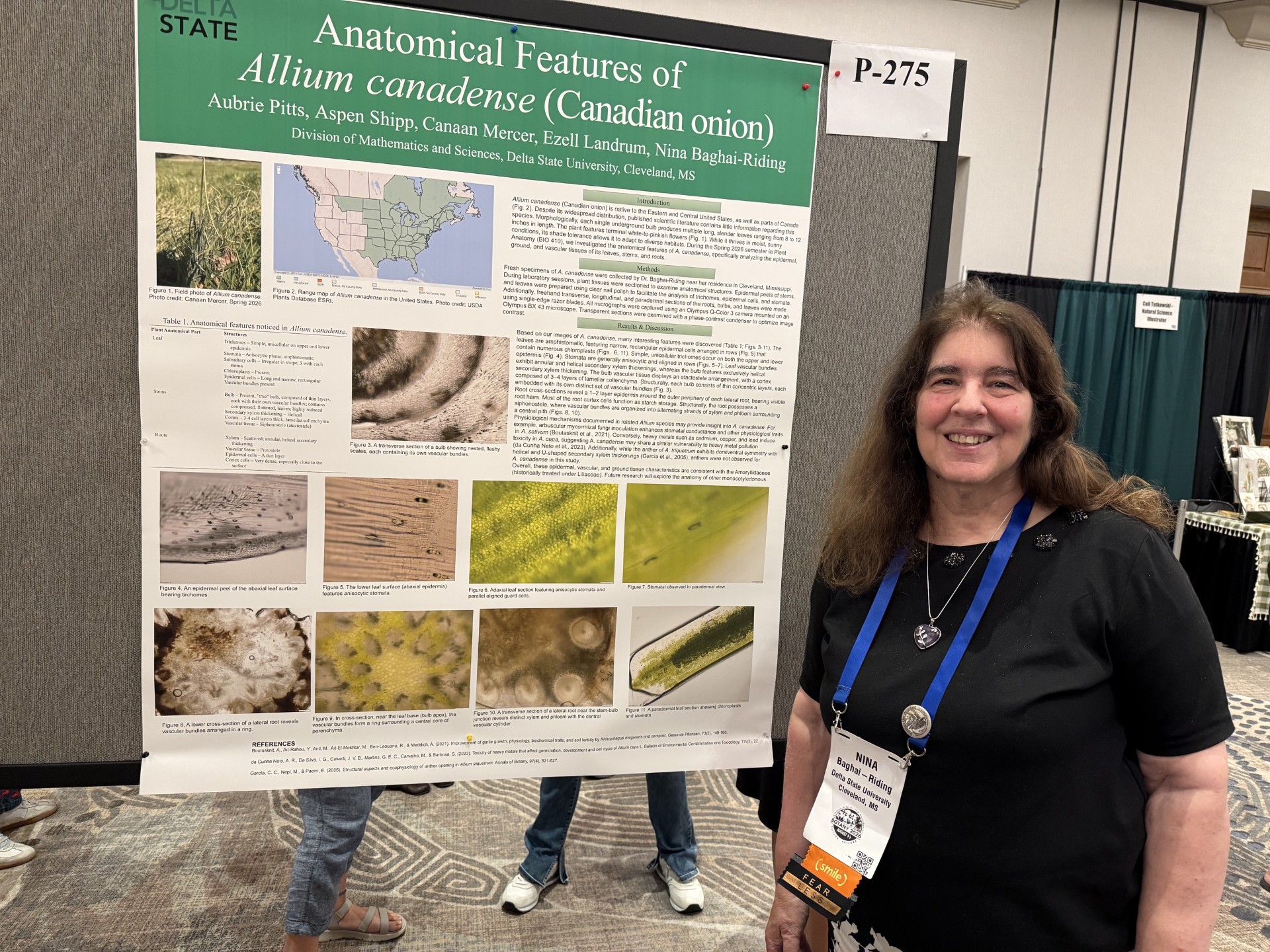 a biology professor posing with a research poster