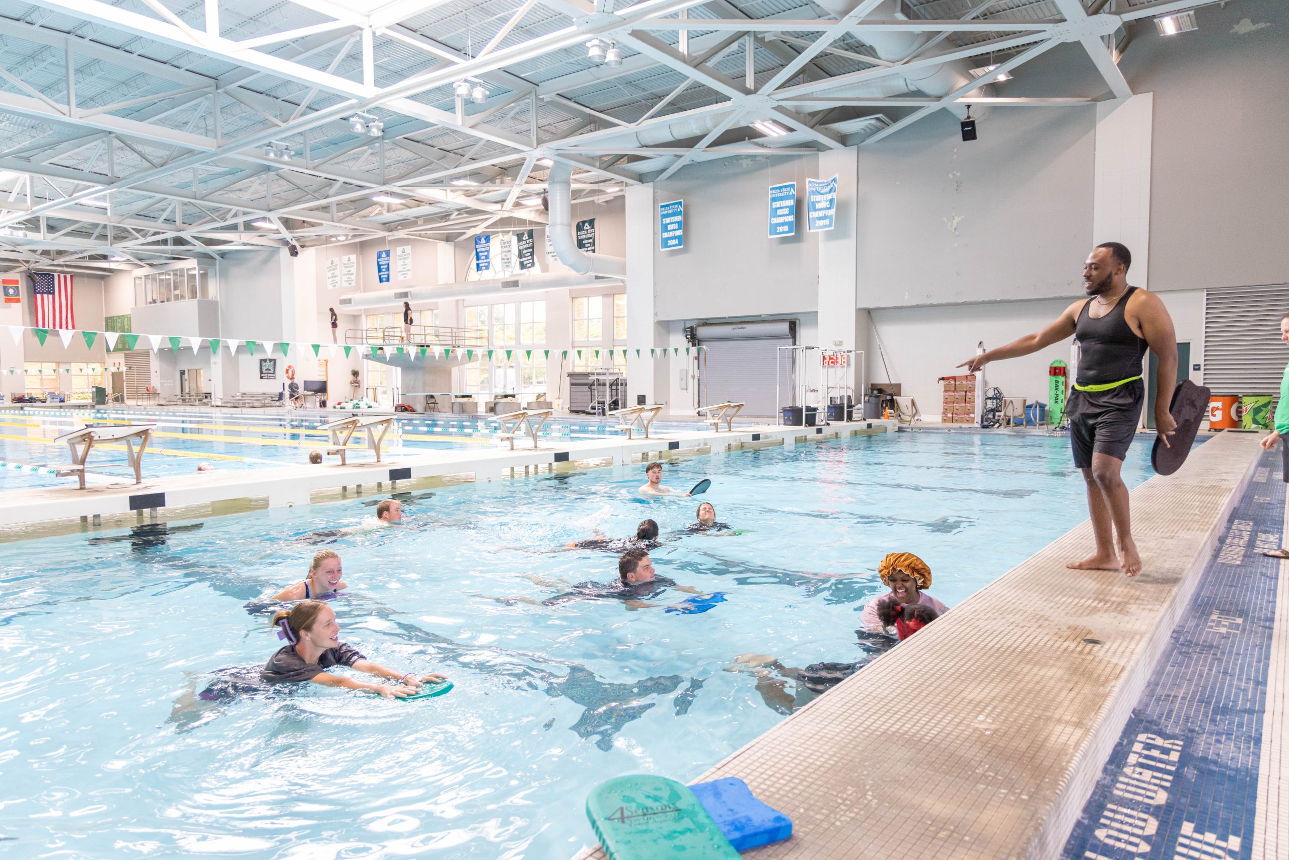 Instructor leading students in an aquatic exercise class in the indoor swimming pool.