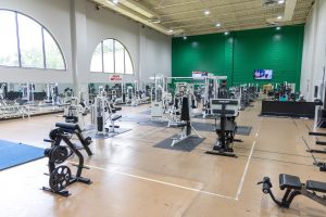 Fitness center with strength-training machines, free weights, and exercise equipment.