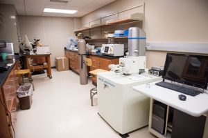 Scientific laboratory featuring specialized analytical equipment and a computer workstation.