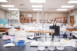 Chemistry laboratory workspace with glassware, funnels, beakers, and other experimental equipment.